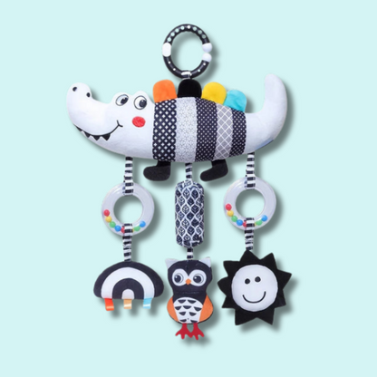 Black and white crocodile sensory hanging toy with rattle rings and high-contrast plush charms for newborn visual and auditory development – Babyroos 0–3 month toy